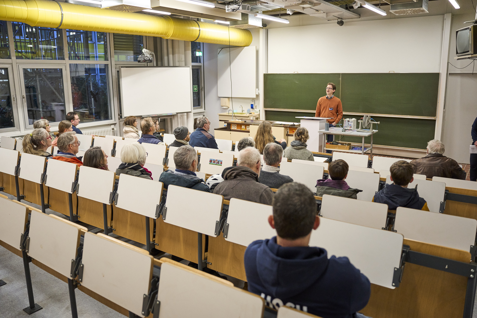 Menschen sitzen in einem Hörsaal und erhalten Sicherheitseinweisung