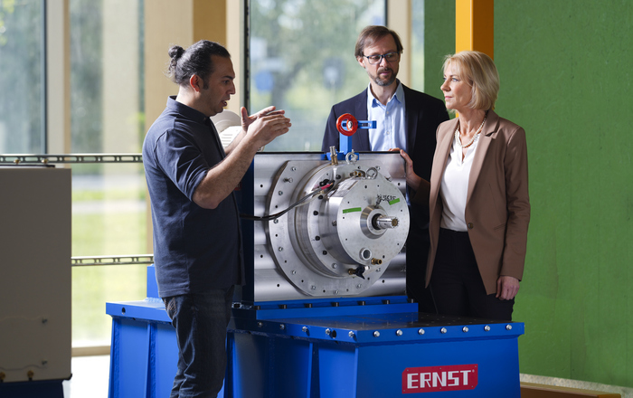 Projektleiter Prof. Dr. Wolfgang Bessler steht mit einem Doktoranden und einer Kollegin am Prüfstand für Hybrid-E-Maschinen.